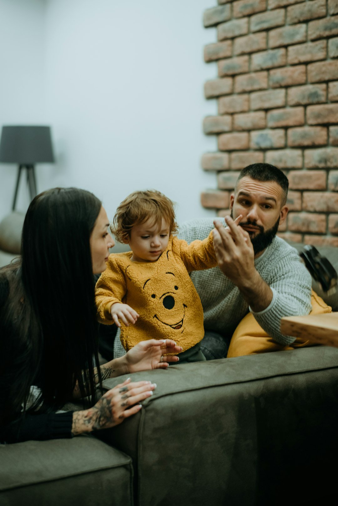 a-man-woman-and-child-sitting-on-a-couch-siwbi8fk-y